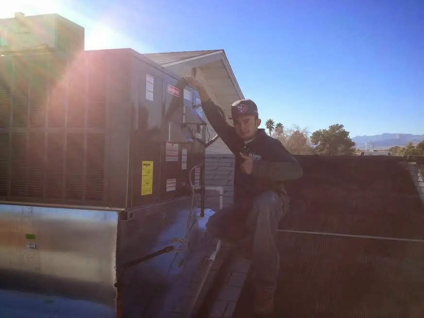 HVAC technician performing AC Tune-Up on a rooftop unit in Phelan